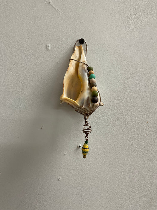 Hanging whelk shell decorated
