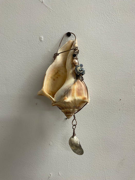 Hanging whelk shell decorated