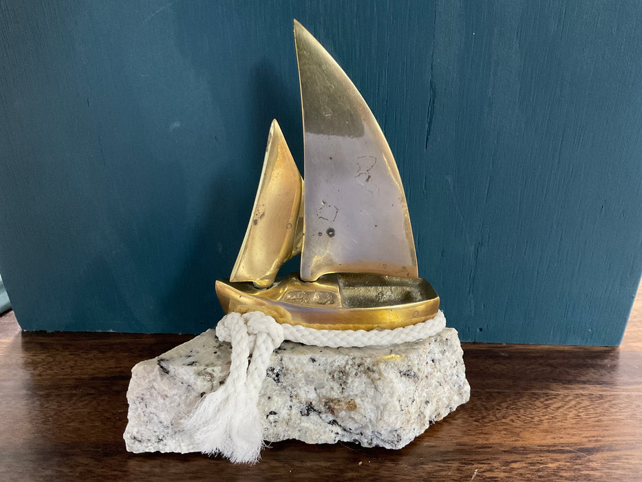 Small brass sailboat on granite