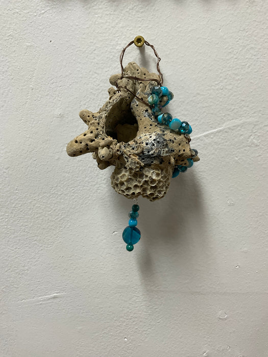 Hanging whelk shell decorated