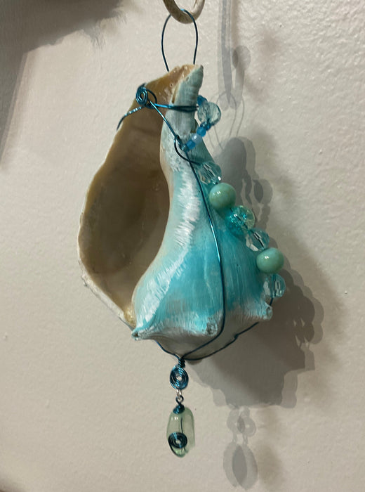 Hanging whelk shell decorated