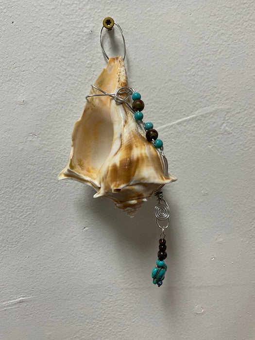 Hanging whelk shell decorated