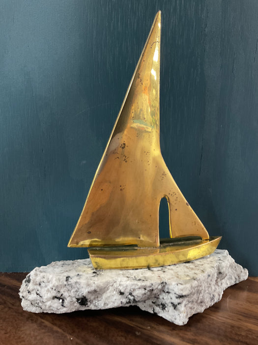 Vintage brass sailboat on granite