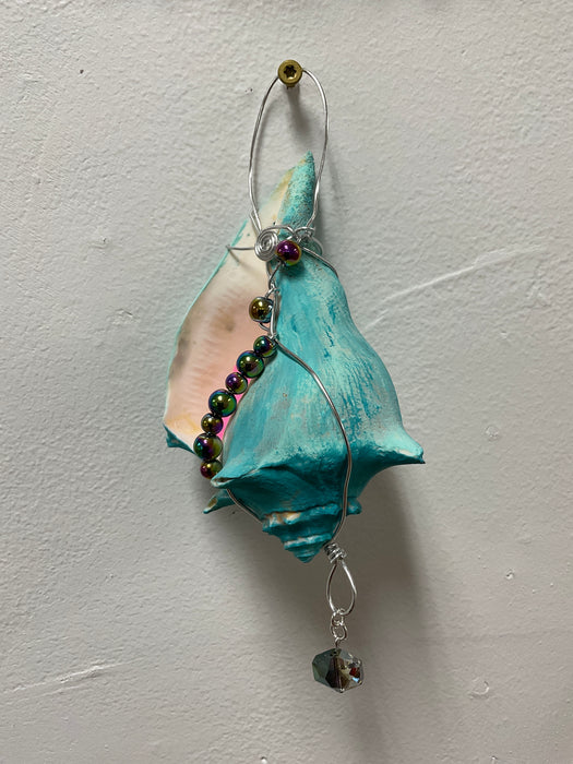 Hanging whelk shell decorated