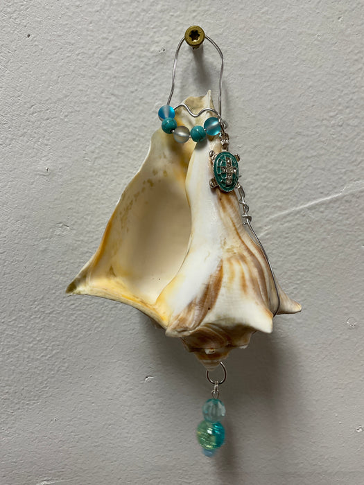 Hanging whelk shell decorated