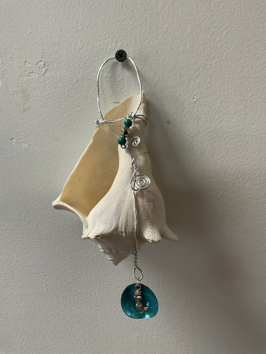 Hanging whelk shell decorated