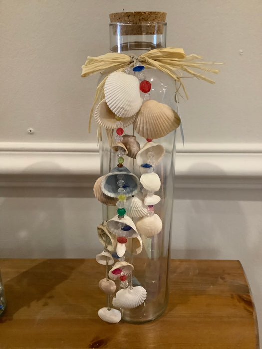 Tall glass bottle with shell garland